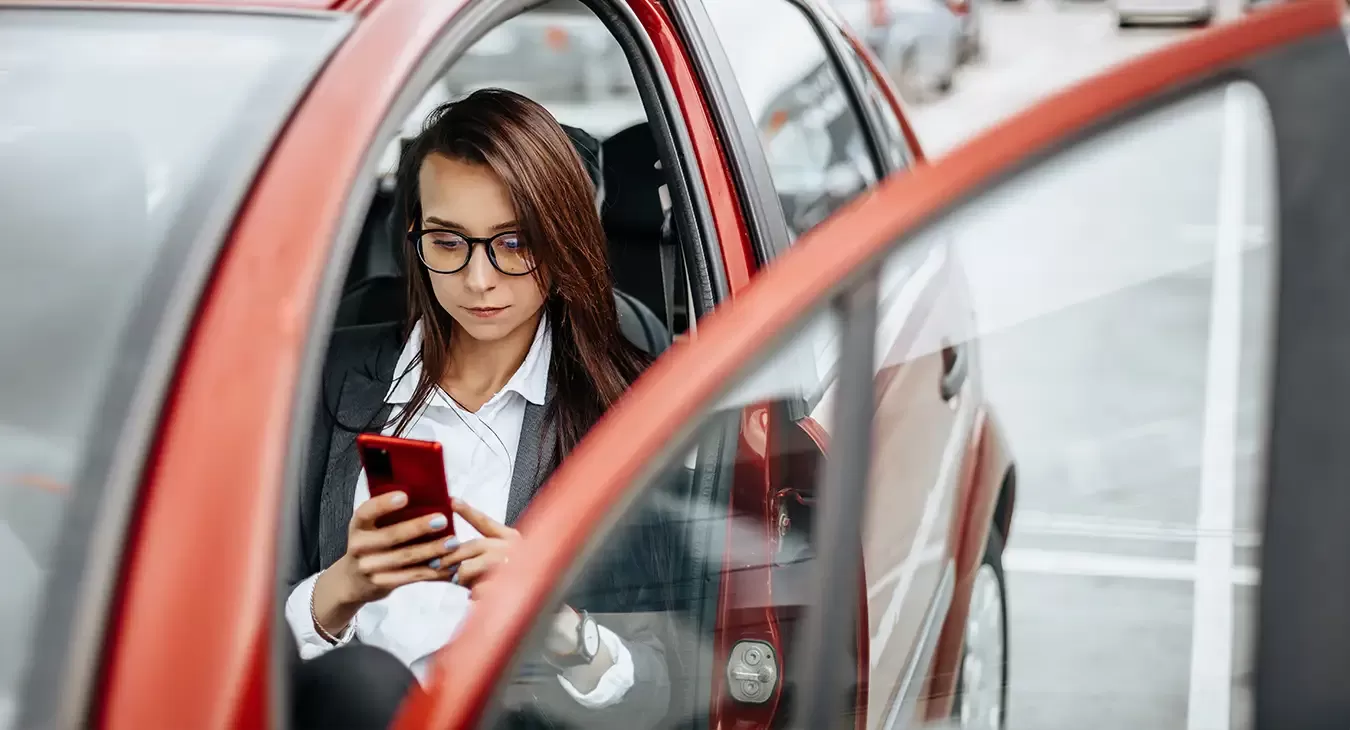 Photo of a woman in a car receiving a text message.